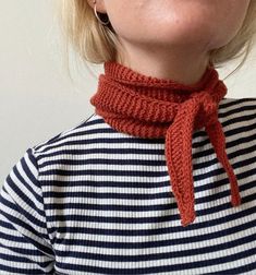 a woman with blonde hair wearing a red scarf around her neck and looking up at the sky