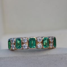 an emerald and diamond ring on display