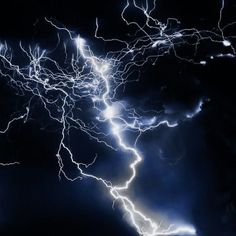 lightning strikes in the night sky with clouds and dark blue hues, as seen from below