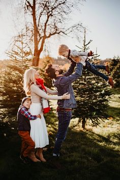 a young family is playing with their child in the park at sunset or sunrise time