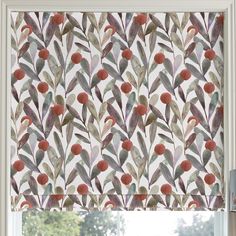 a window with a roman blind decorated with leaves and berries