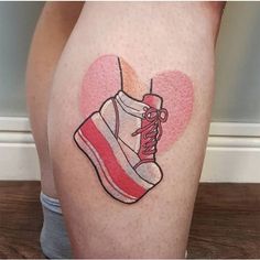 a woman's thigh with a heart shaped shoe tattoo on the side of her leg