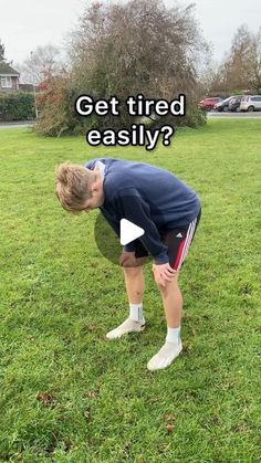 a man bent over in the grass with his head down and hands on his knees