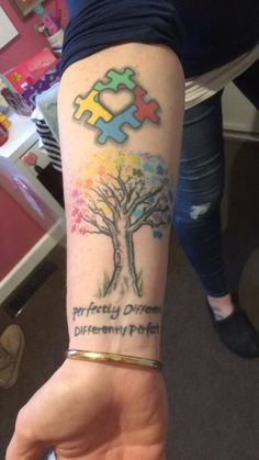 a person with a tattoo on their arm that has puzzle pieces in the shape of a tree