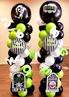 two tall black and white balloons with green accents