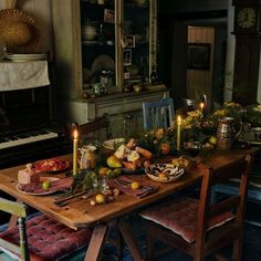 a wooden table topped with lots of food next to a piano in a living room