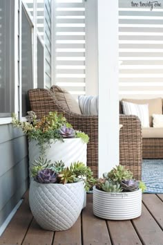 two white planters sitting on top of a wooden deck