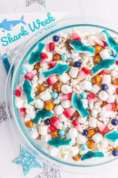 a bowl filled with marshmallows and other candy toppings on top of a table