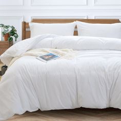 a bed with white sheets and pillows in a room