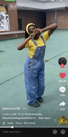 a person in overalls and a yellow shirt is standing on the street with his hands up