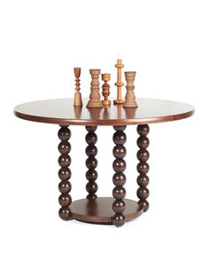 a table with chess pieces on it and two candles in the middle, sitting next to each other