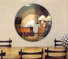 a large round mirror sitting on top of a wooden table