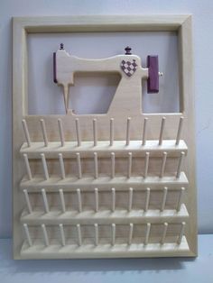 a wooden frame with a sewing machine and pegs in the middle, on a white background