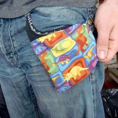 a man is holding his pocket full of colorful fabric items in his jeans and belt