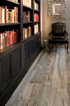 a chair sitting in front of a bookshelf filled with lots of bookcases