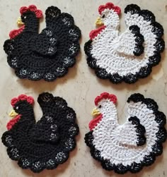 four crocheted chicken coasters sitting on top of a table