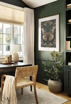 a living room filled with furniture and a painting hanging on the wall above a desk