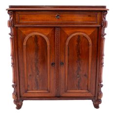 an old wooden cabinet with two doors and carvings on the front, against a white background