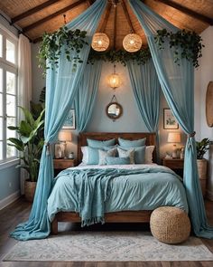 a bed with blue sheets and pillows in a room next to two plants on the wall