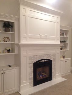 a living room with a fireplace and built in shelves