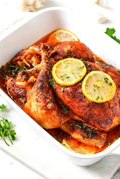 chicken with lemons and parsley in a white casserole dish