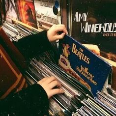 a person is playing an organ in a music store with vinyl records on the shelves