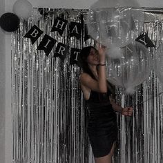 a woman standing in front of balloons and streamers