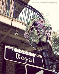 a street sign with beads hanging from it's pole next to a brick building