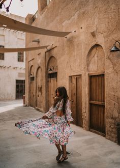 a woman in a floral dress walking down the street