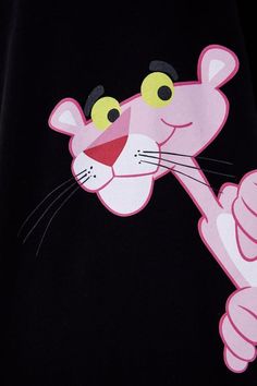 a close up of a pink cat on a black shirt