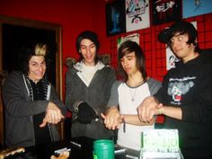 four young men are gathered around a table