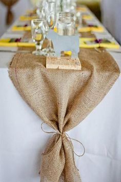 the table is decorated with burlocks and glassware for guests to eat at