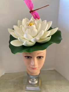 *  This fascinator is whimsical and unique and yet is still elegant and sophisticated in design.  *  This large white water lily has a diameter of 11" and since it curls upwards the lily pad makes it look much larger.  With it's simple profile it can be worn casually or to more sophisticated venues. *  The hot pink dragon fly adds a bit of whimsy. *  On a metal headband it is light weight, well balanced, secure and comfortable to wear. *  Great for any festive event such as an outdoor Beach Wedding or Party, Barbecue, Festive Celebration, Luau, Hawaiian Party, Disneyland Trip, Mad Hatter, Garden or Tea Party, Music Festival or Concert, Parade Participant, Theatrical Performance, Flower Garden Party, Party in the Park, any Horse Racing Event or just for fun! Outdoor Beach Wedding, Pink Dragon, Metal Headbands, Hawaiian Party, Disneyland Trip, White Lilies, Costume Hats, Large White, Mad Hatter