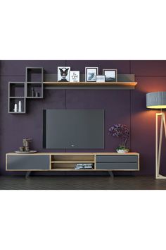 a living room with purple walls and wooden shelves on the wall, along with a gray entertainment center