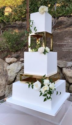 a three tiered cake with white flowers on it