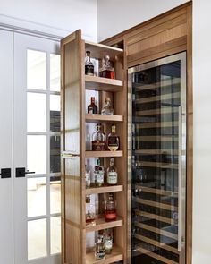 an open wine cabinet with many bottles in it