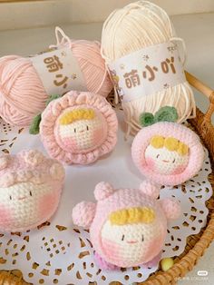 small crocheted toys sitting on top of a doily next to balls of yarn