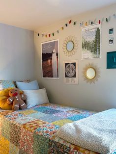 there is a bed with many pictures on the wall above it and a stuffed animal