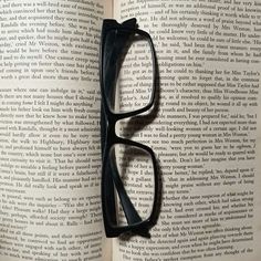 a pair of black glasses resting on top of an open book with the words harry potter written in it