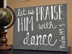 a sign that says, let us praise him with dance on top of a desk