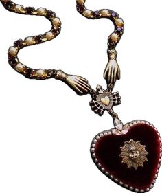 a necklace with a heart shaped pendant on it's end and a cross in the middle