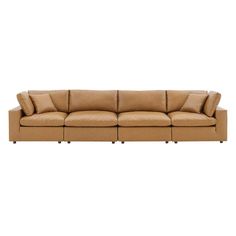 a tan leather couch with four pillows on the back and one arm folded out to show the