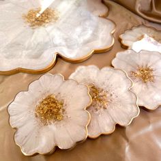 four white and gold flower shaped plates on a table