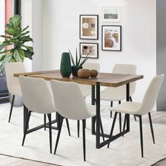 a dining room table with chairs and a potted plant on the table in front of it