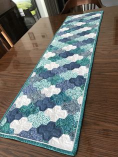 the table runner is made with blue and white quilts on it's edge