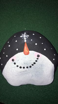 a painted rock with a snowman face on it