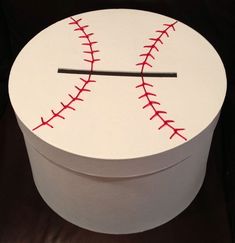 a white box with a baseball painted on the inside and red stitches across the top