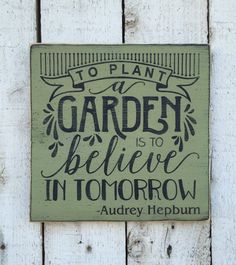 a sign on the side of a building that says to plant a garden is to believe in tomorrow