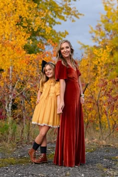 mother and daughter posing in front of fall trees