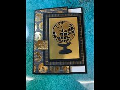 a close up of a card with a gold globe on the front and blue background